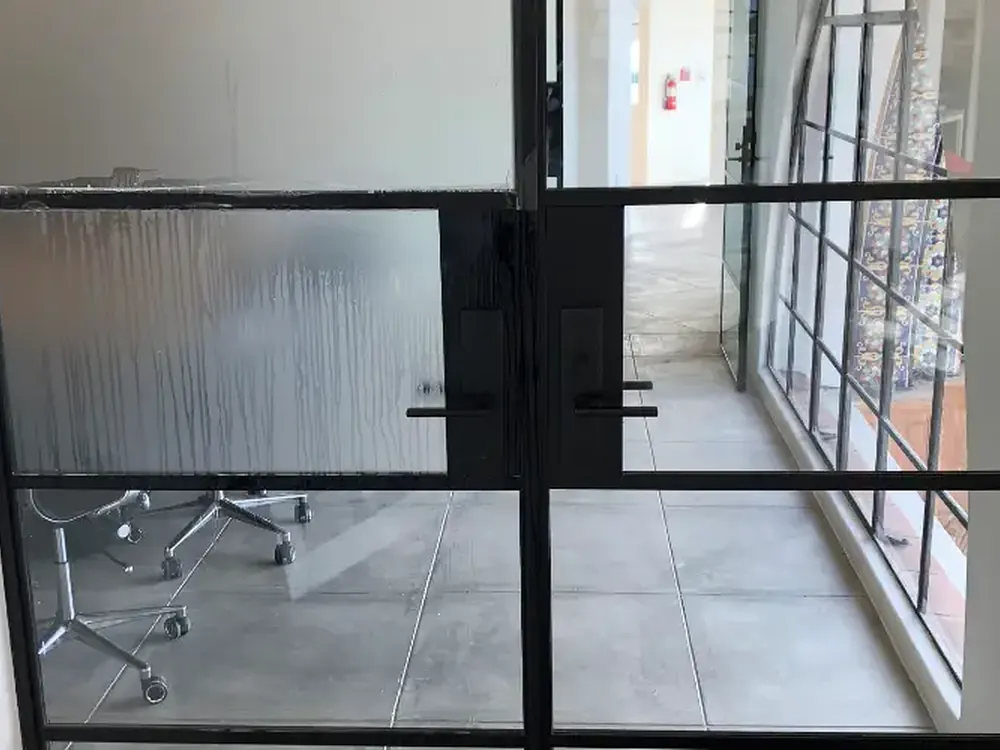 Mid-install: film worked down onto a steel-frame door light.